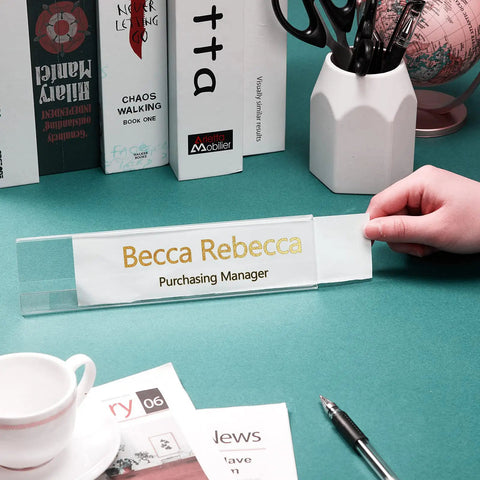Person placing a card into a 24 Pack Acrylic Name Plates For Desk 2x8 Inches Clear Slant Back Sign Holders on a desk.