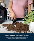 Person using MessMaster Portable Wet Dry Vacuum One Gallon Capacity With True Grip Accessory Suite Corded For Pets And Cars Ultra Powerful Suction For Tough Wet And Dry Messes Burgundy UV105 on a kitchen counter to clean soil.
