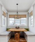 22 Inch Modern Farmhouse 4 Light Drum Pendant Chandelier With Adjustable Height Warm Oak Wood Finish And Textured Black Accents Rustic Chain Link Design For A Bold Vibe And Statement Piece in a cozy dining nook with a wooden table and bench seating.