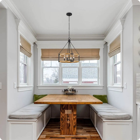 22 Inch Modern Farmhouse 4 Light Drum Pendant Chandelier With Adjustable Height Warm Oak Wood Finish And Textured Black Accents Rustic Chain Link Design For A Bold Vibe And Statement Piece in a cozy dining nook with a wooden table and bench seating.
