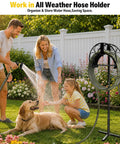 Heavy Duty Freestanding Garden Hose Holder With 50ft Kink-Free Water Hose Kit in use by family in garden with dog.