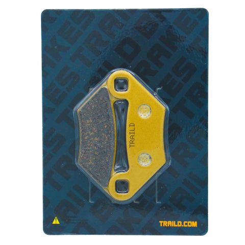 Front view of yellow TrailD Polaris ceramic brake pad on blue packaging.