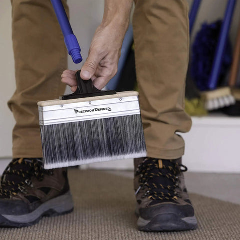 Person holding Large 7 Inch Deck Stain Brush With Extra Thick Bristles for thorough staining of wood and fences, includes pole.