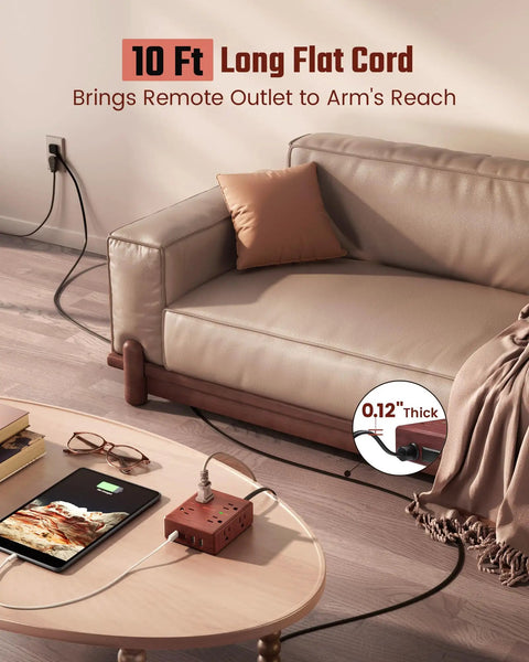 Brown Wood Grain 10 Ft Flat Plug Power Strip With Surge Protector on table near couch, showing long flat cord reaching socket.
