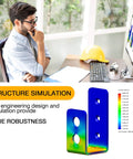 Engineer analyzing structure simulation on computer screen with color-coded diagrams, hard hat on desk