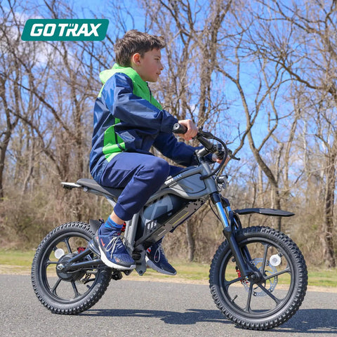 Boy riding off road electric dirt bike with 16 inch pneumatic tires 300W brushless motor 15.5 MPH top speed in black on trail