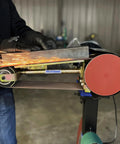 Real Badass 1HP Belt Grinder With Quick Swap 4By48 Inch Belt Auto Tension Rig And 4970 Sfpm Power cutting metal with sparks flying.