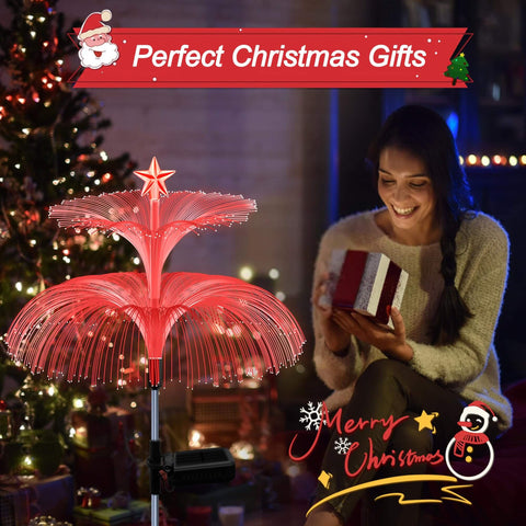 Woman with gift beside Solar Star Jellyfish Garden Lights Six Pack With Color Changing Fiber Optic Glow for festive decor