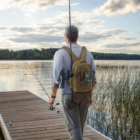 Person walking on a dock with Water Resistant Fishing Backpack With Rod Holder And Padded Straps Lightweight Sling Bag in khaki.