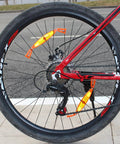 Orange Mountain Bike Reflector Set With Spoke Light And Tail Light installed on rear bike wheel, weatherproof reflective plastic gear