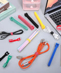 Colorful nylon reusable cable ties, assorted sizes, on desk with wires and stationery. Ditch The Cord Chaos And Snag These Ridiculous 100 Piece Reusable Nylon Cable Ties Color Coded Wire Organizers For Zero Stress Tech Setup And Clean Workspace Storage.