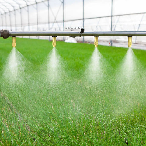 50 Pack Adjustable Brass Misting Nozzles spraying in greenhouse for garden irrigation