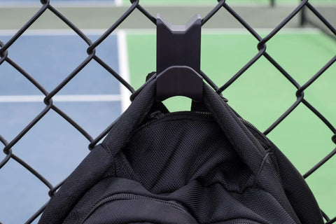 Chain Link Fence Hook For Sports Bags With Paracord Lanyard Heavy Duty Fence Hanger For Baseball Softball Tennis And Pickleball Gear Keeps Gear Clean Off The Ground During Games And Practices hanging a bag on a chain-link fence at a sports court