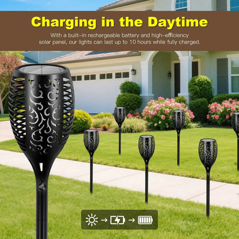 6 solar tiki torches with realistic flickering flames installed in a garden, featuring 4 Pack 96 LED Solar Tiki Torches With Flickering Flame 43 Inch Tall Outdoor Lights Waterproof For Garden Patio Yard Pathway Halloween Decor Easy Setup Durable Night Lighting That Delivers Realistic Fire Look And Cozy Vibe