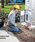 Person using Medium Shock Absorption Kneeling Pad 14 By 21 Inches Black With Handy Handle for outdoor electrical work.