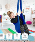 Kick Back And Chill In This Epic Cocoon Sensory Swing For Kids And Grown Ups Indoor Outdoor Therapy Hammock Chair With Buttery Soft Silky Nylon Hug Seat, child using blue nylon swing in a bright room.