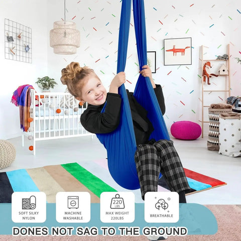 Kick Back And Chill In This Epic Cocoon Sensory Swing For Kids And Grown Ups Indoor Outdoor Therapy Hammock Chair With Buttery Soft Silky Nylon Hug Seat, child using blue nylon swing in a bright room.