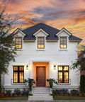 Front view of house with Dusk to Dawn Outdoor Wall Lights With Water Ripple Glass Waterproof Lanterns illuminating the porch at sunset.