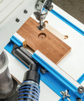 Dust Right Port for Drill Press Fence Portable Dust Collection Attachment in use with wood on drill press table.