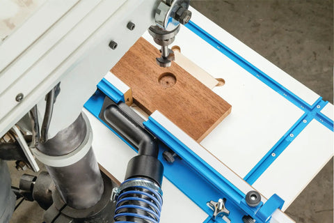 Dust Right Port for Drill Press Fence Portable Dust Collection Attachment in use with wood on drill press table.