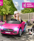 Child in pink 12V Licensed Kids Ride On Electric Car With Remote Control, toddler roadster in a backyard with a dog nearby.