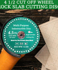 Close-up of diamond cutting disc for grinder, 4.5-inch, 7/8 in arbor, mounted on orange angle grinder beside ceramic tiles.