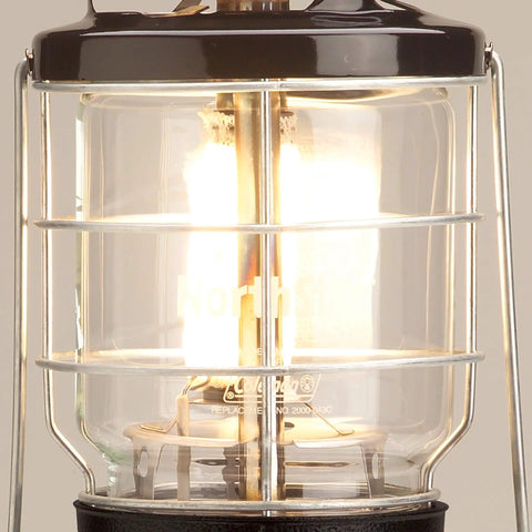 Close-up of the Northstar 1500 Lumen Gas Lantern with matchless lighting, showing bright light through its glass globe and wire guard.