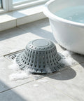 Bathtub Drain Strainer Silicone Bathroom Stopper Fixture in a bathroom with bubbles and a white bathtub.