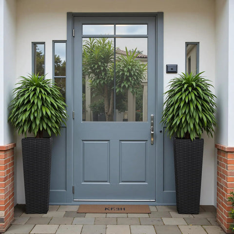 Front view of Resin Tall Planters For Outdoor Plants Set Of 2 Large Tapered Flower Pots With 4 Drainage Holes No Fuss Modern Outdoor Decor For Porch Patio Backyard Home Garden Black 24 Inch placed by a door.