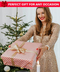 Woman in gold dress holding a wrapped gift in front of a Christmas tree with a sign reading 'Perfect Gift for Any Occasion.'