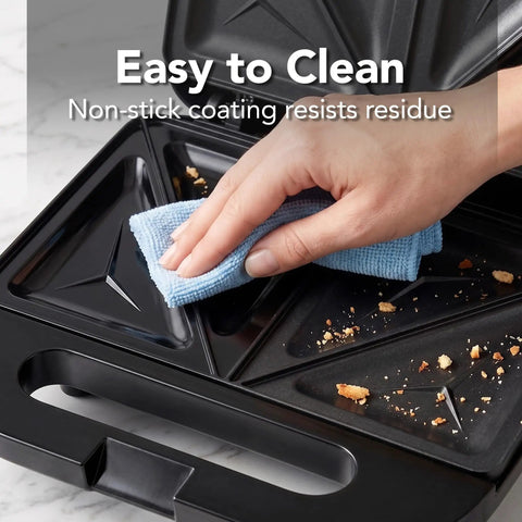 Hand cleaning the non-stick plates of the Ovente Electric Sandwich Maker With Quick Heating Non Stick Plates For Toasting Paninis And Omelets Perfect Hot Pressed Breakfast Grill Machine In Sleek Black Finish Fast Cooking Countertop Appliance.