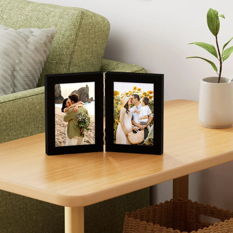 Double 4x6 Picture Frame Vertical From Engineered Wood With Plexiglass Bifold Photo Frame For Tabletop Display Holds Two 4x6 Photos In A Dope Black Finish That Fits Any Desk Or Shelf, placed on a wooden table.