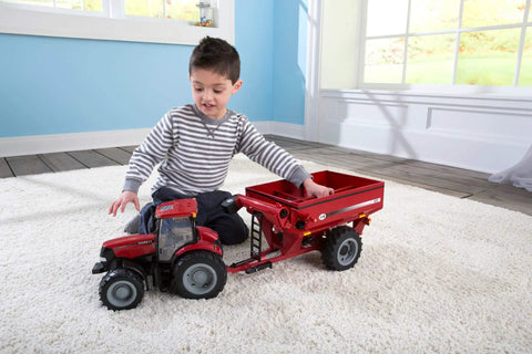 Child playing with Big Farm Tractor Toy For Kids With Realistic Lights And Sounds Opening Hood Removable Front Weights indoors.