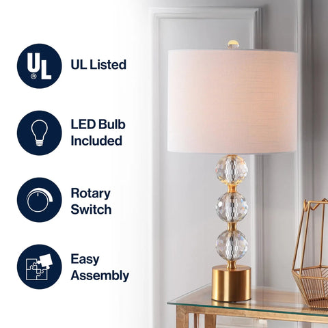 Clear And Brass Gold Crystal Table Lamp With Faceted Orb Design displayed on table, white drum shade, modern glam style.