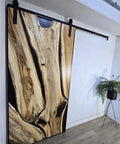 Handcrafted Live Edge Spalted Hackberry Barn Door With Custom Sizing Made To Order In Minnesota Totally One Of A Kind Rustic Modern Wood Door For Hallway Or Entryway, shown from the side angle in an interior setting.