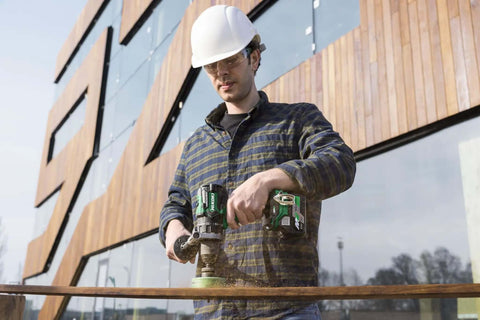 Man using Kickass 36V Brushless Cordless Drill Delivering 155 Nm Torque With Reactive Force Control Tech on wood outdoors.
