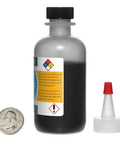 Front view of Graphite Powder 44 Micron 99.9 Percent Pure Mil Spec Eight Ounces In Four Bottles Two Ounces Each with coin for scale.