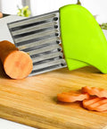 KLEENE stainless steel crinkle cutter with green handle on cutting board; carrot slices nearby