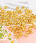 Gold Mini Crown Charms For DIY Jewelry Making 100Pcs Tiny King Crown Beads with 3D Alloy Spacers on a table