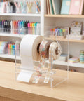 Adjustable Acrylic Label Roll Holder with Three Slots Smooth Dispensing and One Handed Reload Stable Desk Organizer for Office Home and Warehouse Sorting Slick Sticker Tape Keeper for Busy Workdays on wooden desk