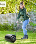 Woman using 20 Inch Push And Tow Behind Lawn Roller With 16 Gallon Water Or Sand Fill Ideal For Flattening Sod And Smoothing Uneven Lawns