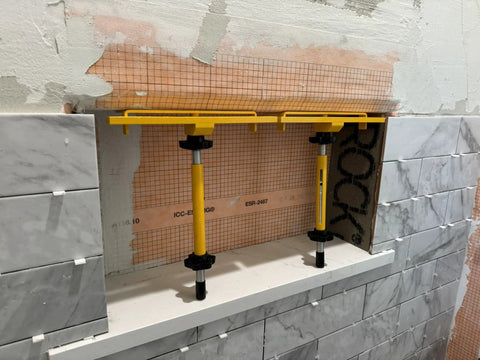 Shower Niche Tiling Tool Kit with aluminum support in use for ceramic tile installation, featuring pro grade niche shelves and spacers.