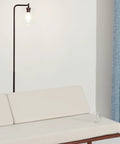 Tall Edison Bulb Floor Lamp With Glass Shade In Bronze Finish beside a white sofa, adding industrial vintage style to room.