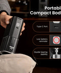 Hand holding Road Trip Ready Portable Electric Coffee Grinder With Adjustable Stainless Steel Burrs, USB Rechargeable in black.