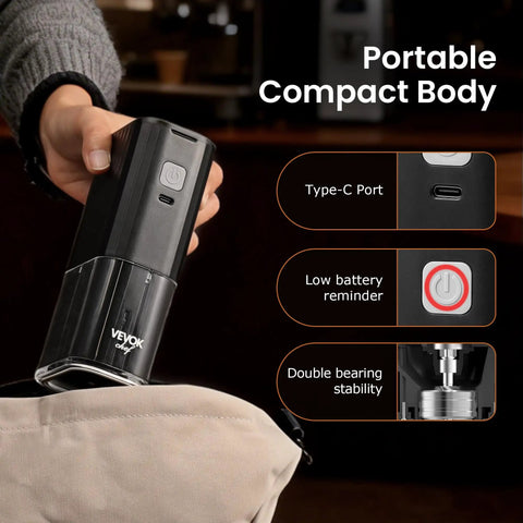 Hand holding Road Trip Ready Portable Electric Coffee Grinder With Adjustable Stainless Steel Burrs, USB Rechargeable in black.