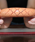 Person holding hot dog with crisscross cuts made by Crosshatch Hot Dog Slicer Tool With Stainless Steel Blades 10 Inch Red Cutter for kitchen.