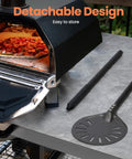 7 Inch Pizza Turning Peel With Extra Long Handle, Perforated Aluminum next to outdoor oven on marble surface.