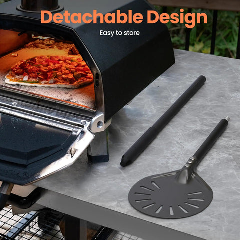 7 Inch Pizza Turning Peel With Extra Long Handle, Perforated Aluminum next to outdoor oven on marble surface.