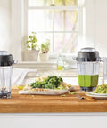 Two Go-To 32 Oz Blender Containers For C-Series And G-Series BPA-Free Eastman Tritan with green smoothie and ingredients on counter