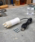 Portable Submersible Sump Pump With Built In Filter And Extended Drain Hose Heavy Duty Water Rig on workbench with tools.